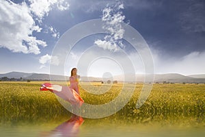 Beauty Romantic Girl Outdoors. Beautiful Teenage Model Dressed in Long Pink Dress on the Field in Sun Light. Blowing Long Hair.