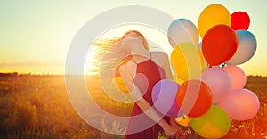 Beauty romantic girl on summer field with colorful air balloons