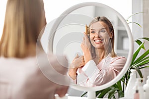 Beauty Routine. Attractive Middle Aged Woman Combing Her Beautiful Hair With Brush