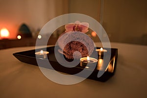 Beauty salon decoration in massage room, candles, towel and orchid.