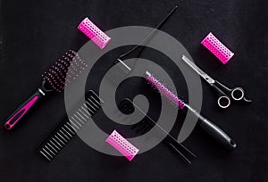 Hairdresser equipment for cutting hair and styling with combs, sciccors, brushes on black background top view pattern