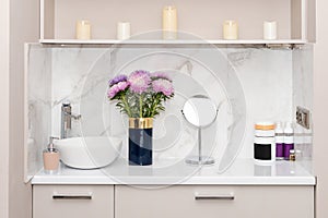 Beauty salon interior. Set of natural cosmetics, jars of body or hair care product on table with flowers