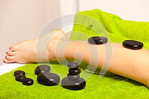 Beauty salon. Woman getting spa hot stone legs massage