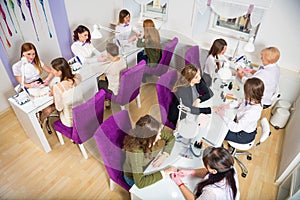 Beauty salon. Women doing manicure. Manicure specialists in the workplace