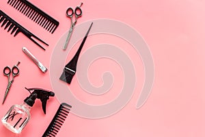 Beauty saloon accessories - combs, sciccors for hairdressing - on pink background top-down frame copy space