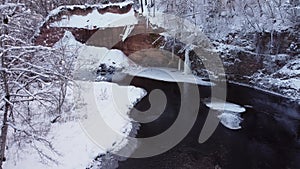 Beauty of sand cliff and frozen forest. Riversides and trees covered with snow. Winter nature landscape. Low flight