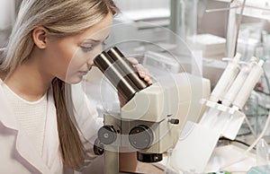 Beauty scientist Looks in microscope in chemical laboratory