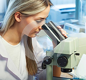 Beauty scientist Looks in microscope in chemical laboratory