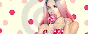 Beauty sexy model woman with pink hairstyle and beautiful makeup holding lollipop candy