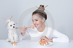 Beauty sexy woman eating sushi. Sushi rolls, sashimi. Fashion model girl eating Sushi with chopsticks. Haircut with