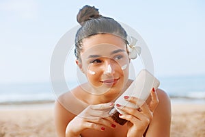 Beauty Sexy Young Woman in Bikini Holding Bottles of Sunscreen in Her Hands. Skin care. A Beautiful Female Applying Sun Cream.