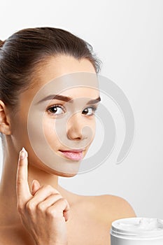 Beauty Skin Care. Beautiful Happy Woman Applying Cosmetic Cream On Clean Face.