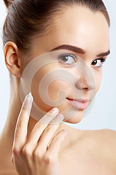 Beauty Skin Care. Beautiful Happy Woman Applying Cosmetic Cream On Clean Face.