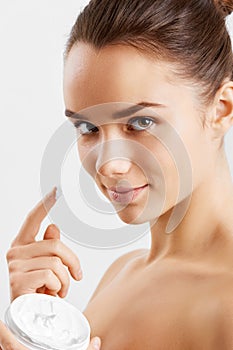 Beauty Skin Care. Beautiful Happy Woman Applying Cosmetic Cream On Clean Face.