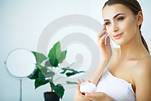 Beauty Skin Care. Beautiful Woman Applying Cosmetic Face Cream