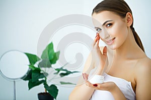 Beauty Skin Care. Beautiful Woman Applying Cosmetic Face Cream