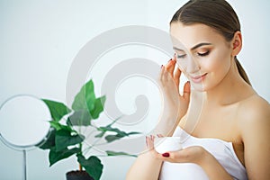 Beauty Skin Care. Beautiful Woman Applying Cosmetic Face Cream