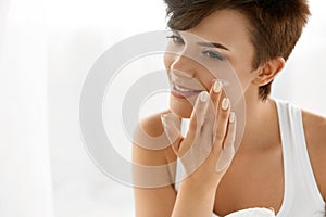 Beauty Skin Care. Beautiful Woman Applying Cosmetic Face Cream