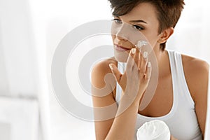 Beauty Skin Care. Beautiful Woman Applying Cosmetic Face Cream