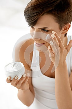 Beauty Skin Care. Beautiful Woman Applying Cosmetic Face Cream