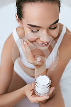 Beauty Skin Care. Beautiful Woman Applying Cream On Face Skin