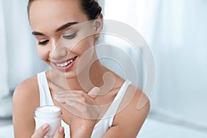 Beauty Skin Care. Beautiful Woman Applying Cream On Face Skin