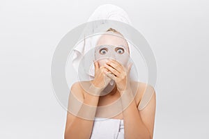 Beauty Skin Care Concept - Beautiful Caucasian Woman applying paper sheet mask on her face white background.