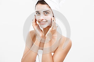Beauty Skin Care Concept - Beautiful Caucasian Woman Face Portrait applying cream mask on her facial skin white
