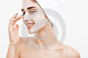 Beauty Skin Care Concept - Beautiful Caucasian Woman Face Portrait applying cream mask on her facial skin white