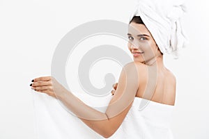 Beauty and Skin care concept - Beautiful caucasian Young Woman with bath towel on head covering her breasts, on white