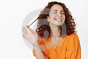 Beauty skin care. Portrait of natural young woman with red curly hair, laughing happy, white smile teeth, playing with