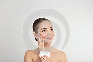 Beauty skin woman natural makeup face cosmetic concept.Beautiful portrait of female face holding and applying cosmetic cream.