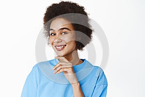 Beauty an skincare. Close up portrait of beautiful happy african american woman, touching glowing facial skin, smiling