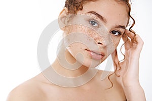 Beauty, skincare concept. Tender redhead young woman naked freckles look camera sensually gently touching pure clean