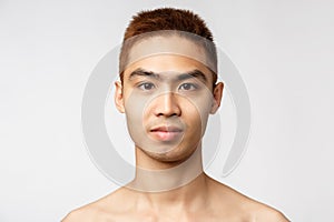 Beauty, skincare and men health concept. Headshot of handsome young asian man with no blemishes, perfect skin condition photo