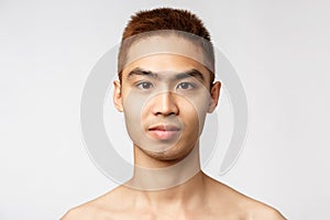 Beauty, skincare and men health concept. Headshot of handsome young asian man with no blemishes, perfect skin condition