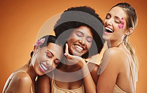 Beauty, skincare and model women in studio with flowers, makeup and cosmetics by brown background. Diversity, happiness