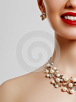 Beauty smiles . Red lipstick and jewelry . Beauty and fashion . Clean skin of a young girl . Concept for a