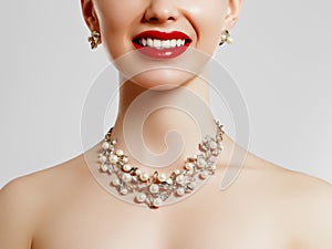 Beauty smiles . Red lipstick and jewelry . Beauty and fashion . Clean skin of a young girl . Concept for a