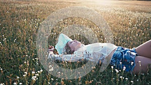 Beauty smiling girl laying on the spring field. Meadow. Portrait of laughing and happy young model woman with healthy