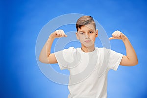 Beauty smiling sport child boy showing his biceps