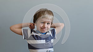 Beauty smiling sport child boy showing how strong he is