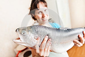 Beauty smiling woman holding raw salmon or trout fish food