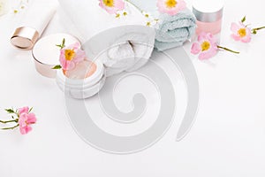 Beauty and spa concept. Towel and skin care cosmetics with rose hips on a white background. Flat lay