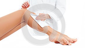 Beauty Spa. Hair removal cosmetology procedure. Beautician waxing female legs photo