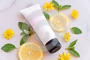 Beauty spa medical skincare and cosmetic lotion tube cream packaging product on white marble background with lemon slices. fruit