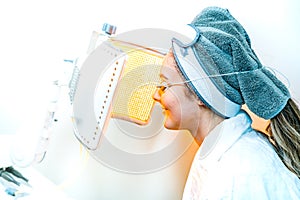 Beauty spa patient undergoing LED Photomodulation for a light-based facial, as an anti-aging treatment, and for sunburn healing