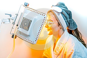 Beauty spa patient undergoing LED Photomodulation for a light-based facial, as an anti-aging treatment, and for sunburn healing