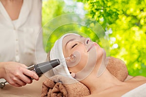 Woman having hydradermie facial treatment in spa photo