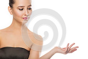 Beauty spa woman with perfect skin portrait. Beautiful brunette spa girl showing empty copy space on the open hand palm for text.